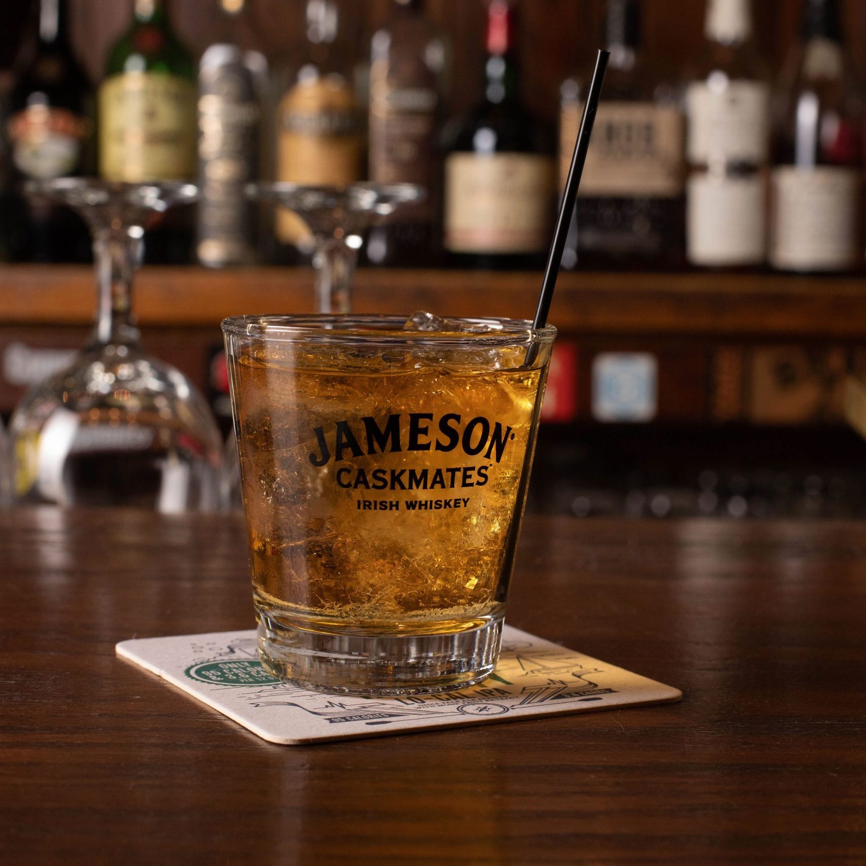 A glass of jackson's whiskey on a bar top.